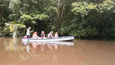 a group of people in a boat on a river at Tortuguero Adventures GuestHouse in Tortuguero