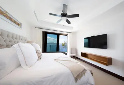 a bedroom with a bed and a flat screen tv at 360 Splendor Del Pacifico Residences in Playa Flamingo