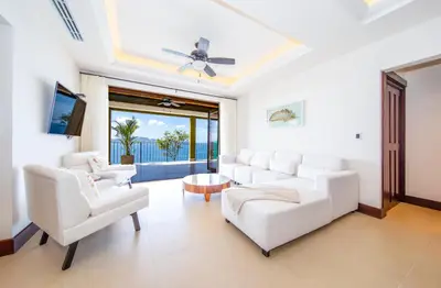 a living room with white furniture and a ceiling fan at 360 Splendor Del Pacifico Residences in Playa Flamingo