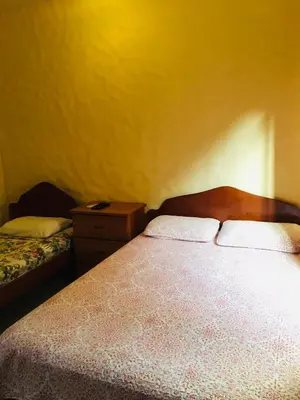 a bedroom with a bed and a dresser and a bed sidx sidx at Hotel Casa Esmeralda in Sámara