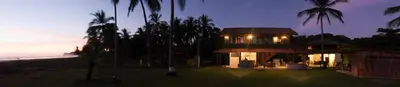 a building on the beach with palm trees at night at Totobe Resort in Jabilla