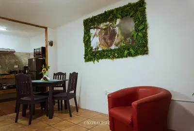 a dining room with a table and a red chair at Hotel Santa Fe B&B in Monteverde Costa Rica