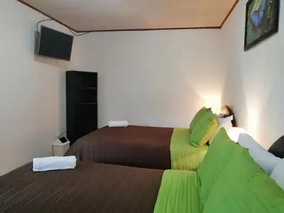 a hotel room with two beds and a tv at Hotel Santa Fe B&B in Monteverde Costa Rica