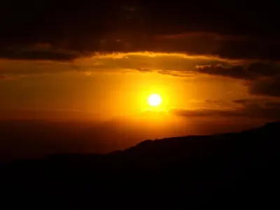 a sunset over a mountain with the sun in the sky at Hotel Santa Fe B&B in Monteverde Costa Rica
