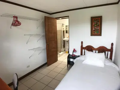 a bedroom with a bed and a bathroom at Casa Kibi Kibi in San José