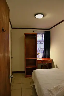 a bedroom with a bed and a desk and a window at Casa Kibi Kibi in San José