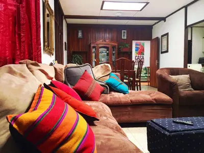 a living room with a couch with colorful pillows at Casa Kibi Kibi in San José
