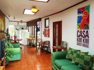 a living room with green couches and a table at Casa Kibi Kibi in San José