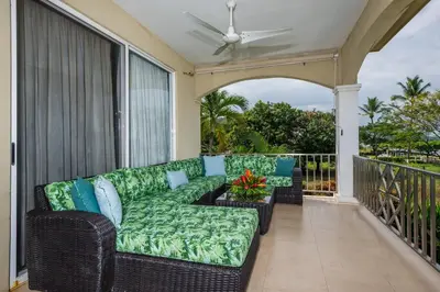 a couch on a balcony with a ceiling fan at Beachfront Potrero - nice 7-BR villa, private cook included - Casa Royal in Potrero