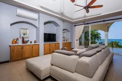 a living room with a couch and a flat screen tv at Beachfront Potrero - nice 7-BR villa, private cook included - Casa Royal in Potrero