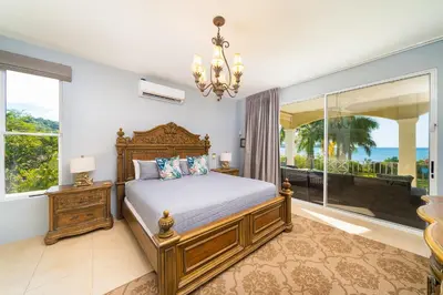 a bedroom with a bed and a large window at Beachfront Potrero - nice 7-BR villa, private cook included - Casa Royal in Potrero