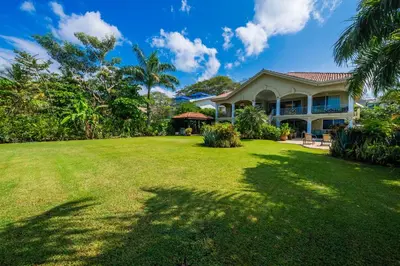 a house with a large lawn in front of it at Beachfront Potrero - nice 7-BR villa, private cook included - Casa Royal in Potrero