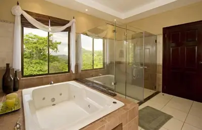 a large bathroom with a large tub and a shower at Playa Potrero, Oceanview Villa Oasis with salt-water pool for up to 8 people in Potrero