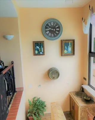 a clock on a wall with two pictures on it at Playa Potrero, Oceanview Villa Oasis with salt-water pool for up to 8 people in Potrero