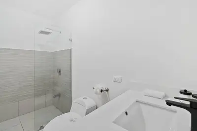 a white bathroom with a shower and a toilet at Playa Potrero - beachfront Villa, big private pool - Casa Bella Catalina in Potrero