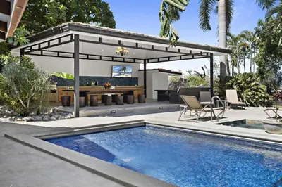 a patio with a swimming pool and a pergola at Playa Potrero - beachfront Villa, big private pool - Casa Bella Catalina in Potrero
