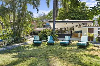 a group of blue chairs in front of a house at Playa Potrero - beachfront Villa, big private pool - Casa Bella Catalina in Potrero