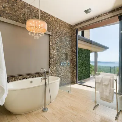a bathroom with a large tub and a glass door at Casa Symbiotica - Exclusive Villa with Gym, Infinity Pool & Housekeeping in Brasilito