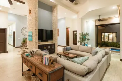 a living room with a couch and a table at Casa Symbiotica - Exclusive Villa with Gym, Infinity Pool & Housekeeping in Brasilito
