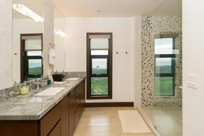 a bathroom with two sinks and two windows at Casa Symbiotica - Exclusive Villa with Gym, Infinity Pool & Housekeeping in Brasilito
