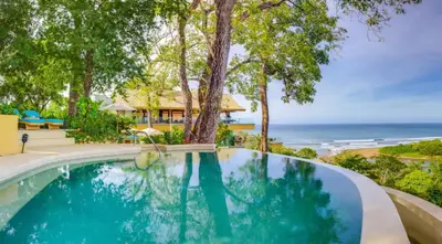 a swimming pool with a view of the ocean at Hotel Boutique Lagarta Lodge in Nosara