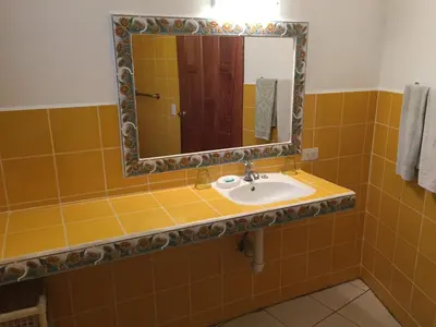 a bathroom with a sink and a mirror at La Perlita in Jacó