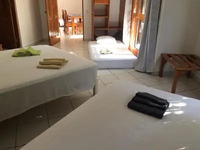 a room with two beds with towels on them at La Perlita in Jacó