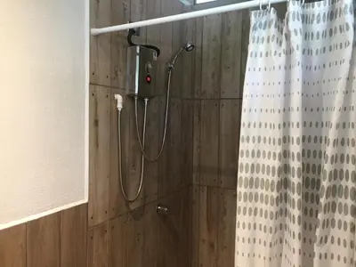 a shower in a bathroom with a shower curtain at La Perlita in Jacó