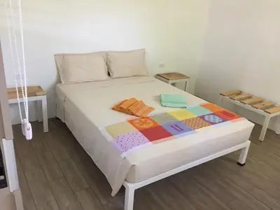 a bedroom with a bed with a quilt on it at La Perlita in Jacó