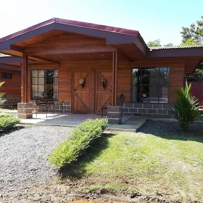 a house with a large wooden door and a porch at Cabañas San Isidro in Ángeles