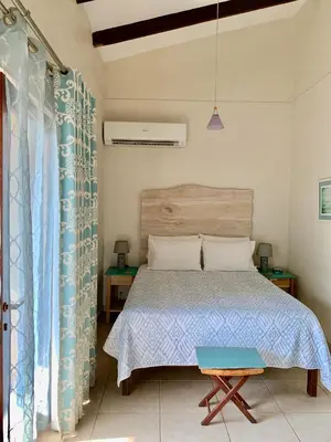 a bedroom with a bed with a wooden headboard at Ten North Tamarindo Beach Hotel in Tamarindo