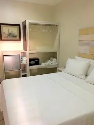a bedroom with a large white bed and a tv at Ten North Tamarindo Beach Hotel in Tamarindo