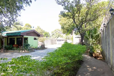 a house with a green building next to a driveway at Hotel Villa Hermosa in Liberia