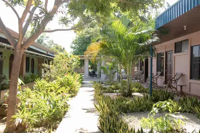 a courtyard of a house with trees and plants at Hotel Villa Hermosa in Liberia