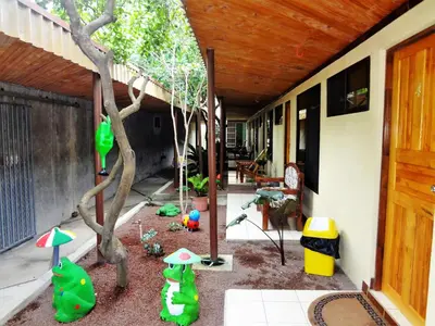 a backyard with a tree and a house at Hotel Villa Hermosa in Liberia