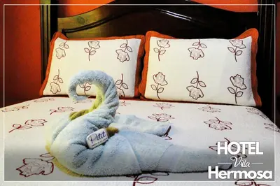 a bed with a blue stuffed bird on it at Hotel Villa Hermosa in Liberia