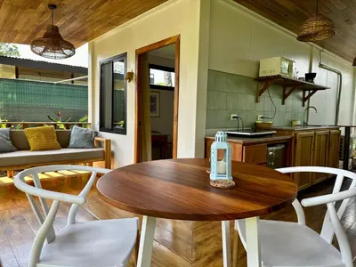 a kitchen and dining room with a wooden table and chairs at Almendros Eco-Villas in Fortuna