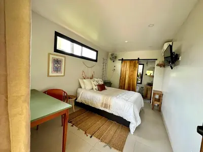 a bedroom with a bed and a table and a window at Almendros Eco-Villas in Fortuna