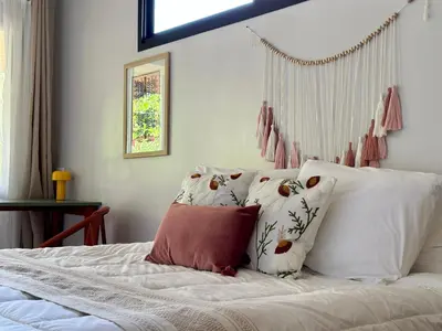a bedroom with a bed with white sheets and pillows at Almendros Eco-Villas in Fortuna