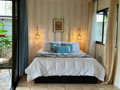 a bedroom with a large bed with blue pillows at Almendros Eco-Villas in Fortuna