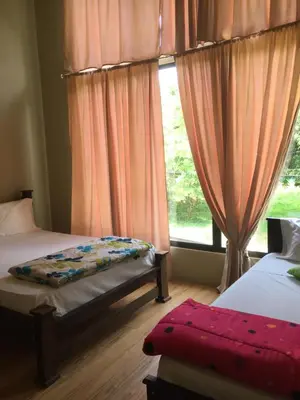 a bedroom with two beds and a window at Casa Playa Bahia Ballena de Osa in Uvita