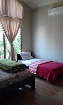 a bedroom with two beds and a window at Casa Playa Bahia Ballena de Osa in Uvita