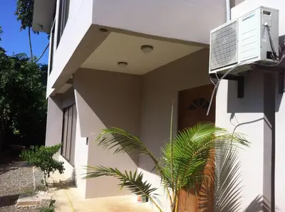 a white building with a plant in front of it at Casa Playa Bahia Ballena de Osa in Uvita