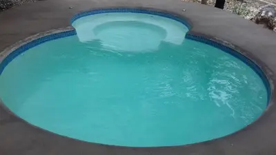 a large pool of blue water in a yard at Villa De Los Monos, casitas equipadas en Guanacaste in Matapalo