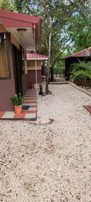 a house with a gravel yard in front of a house at Villa De Los Monos, casitas equipadas en Guanacaste in Matapalo