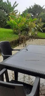 a table and chairs sitting on a patio at Montaña Linda Guest House Orosi in Orosí
