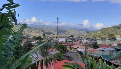 a view of a town with mountains in the background at Montaña Linda Guest House Orosi in Orosí