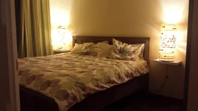 a bedroom with a bed with pillows and two lamps at Montaña Linda Guest House Orosi in Orosí