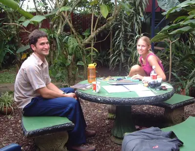 a man and a woman sitting at a table at Montaña Linda Hostel Orosi in Orosí