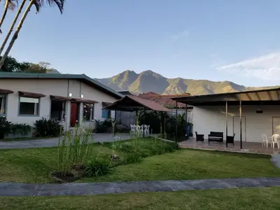 a house with a patio with mountains in the background at Hotel Monte Campana Escazu in San José